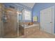 Lovely bathroom features a separate tub, large shower with glass door, and tiled floor at 8116 Mosby Way, Willow Springs, NC 27592