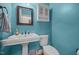 Cozy teal-colored bathroom features a pedestal sink, toilet, and medicine cabinet at 8116 Mosby Way, Willow Springs, NC 27592