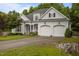 Charming two-story home with a well-manicured lawn, flowering plants, and a two car garage at 8116 Mosby Way, Willow Springs, NC 27592