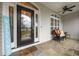 Inviting front porch with decorative glass door, stone flooring, and comfortable seating at 8116 Mosby Way, Willow Springs, NC 27592