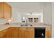 Kitchen counter top featuring a stainless steel sink, black dishwasher, and view to Gathering room at 8151 Rhiannon Rd, Raleigh, NC 27613