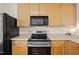 Close up of modern kitchen featuring stainless steel oven, microwave, and wood cabinets at 8151 Rhiannon Rd, Raleigh, NC 27613