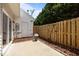 Cozy backyard patio area featuring a wooden fence, a flower pot, and a door to a utility room at 8151 Rhiannon Rd, Raleigh, NC 27613
