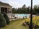 Beautiful community pool surrounded by landscaping, a fence, and lots of lounge chairs at 8151 Rhiannon Rd, Raleigh, NC 27613