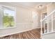 Bright foyer featuring wood-look flooring, a staircase, and a view to the front door at 816 Kimpton Ct, Fuquay Varina, NC 27526