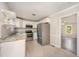 Well-lit kitchen featuring stainless steel appliances and a combination of white cabinets and open shelving at 816 Kimpton Ct, Fuquay Varina, NC 27526