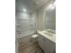 Well-lit bathroom with a shower-tub combo, granite countertop vanity, and wood-look flooring at 85 Bald Cypress Ln, Youngsville, NC 27596