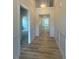Bright hallway with hardwood floors, white wainscoting, and access to multiple rooms at 85 Bald Cypress Ln, Youngsville, NC 27596