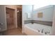 Bathroom with soaking tub, tiled walls, and a view into a large walk-in closet at 966 Airedale Trl, Garner, NC 27529