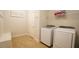 Functional laundry room with modern appliances, tile floor, storage, and stylish decor at 966 Airedale Trl, Garner, NC 27529