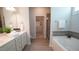 Luxurious main bathroom featuring double vanity, soaking tub, tiled shower, and walk-in closet at 966 Airedale Trl, Garner, NC 27529