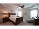 Comfortable main bedroom boasts tray ceilings, a ceiling fan, and cozy seating area with large windows at 966 Airedale Trl, Garner, NC 27529