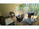 Relaxing screened-in porch features comfortable wicker furniture, a grill, a fire pit table, and a ceiling fan at 966 Airedale Trl, Garner, NC 27529