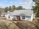 The home's backyard features a wooden deck and stone retaining walls and convenient access steps at 100 W Acres Cres, Cary, NC 27519