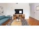 Staged living room with hardwood floors, modern furniture, and a large television at 1002 Willow Drive # 63, Chapel Hill, NC 27514