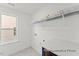 Well-lit laundry room featuring tile floors, white walls, a utility sink, and shelving for storage at 106 S Buggy Dr # 70, Benson, NC 27504