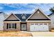 New brick home with a two-car garage, shingle and stone accents, and a well-manicured lawn at 1079 Fairhaven Dr # 50, Mebane, NC 27302