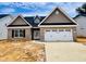 New brick home with a two-car garage, shingle and stone accents, and a well-manicured lawn at 1079 Fairhaven Dr # 50, Mebane, NC 27302