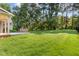 Expansive backyard featuring lush green lawn, mature trees, stone fireplace, and a well-manicured landscape at 1096 Silverleaf Dr, Youngsville, NC 27596
