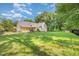 Spacious backyard offers ample green space, trees, an outdoor fireplace, and covered porch, perfect for relaxing at 1096 Silverleaf Dr, Youngsville, NC 27596