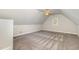 An open and airy bonus room featuring neutral walls, patterned carpet, a window, and a ceiling fan at 1096 Silverleaf Dr, Youngsville, NC 27596
