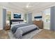 Serene bedroom with a tray ceiling, ceiling fan, hardwood floors, and large windows at 1096 Silverleaf Dr, Youngsville, NC 27596