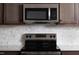 Stainless steel microwave and stove top range are above the white quartz countertops at 11751 Salers Loop Loop, Middlesex, NC 27557