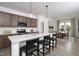 A modern kitchen features an island with bar seating, pendant lights and stainless steel appliances at 11751 Salers Loop Loop, Middlesex, NC 27557