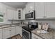 Close-up of kitchen with stainless steel oven, granite countertops, and white cabinets at 119 Yadkin St, Clayton, NC 27520