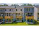 Back exterior view of townhomes featuring decks and patios overlooking green lawns, perfect for outdoor living at 1359 Chowan Ave, Durham, NC 27713