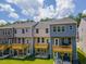 Townhome back exteriors offer raised wooden decks, doors to backyard, and lush lawn for relaxation and play at 1359 Chowan Ave, Durham, NC 27713