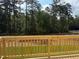View from the back porch with wood railings looking out over the lush green yard and treeline at 1359 Chowan Ave, Durham, NC 27713