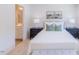 Bright bedroom features neutral walls, modern furniture, and decor with a view into the en suite bathroom at 1359 Chowan Ave, Durham, NC 27713