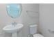 Powder room with modern pedestal sink, faucet, toilet, fixtures, and a mirror at 1359 Chowan Ave, Durham, NC 27713