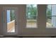 Bright natural light from the window and door illuminate the unfinished room with a view to the porch at 1359 Chowan Ave, Durham, NC 27713