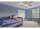 Cozy bedroom with carpeted floors, a ceiling fan, and a drum set with a window view at 136 Garden Retreat Dr, Garner, NC 27529