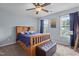 Comfortable bedroom with a wooden bed frame, an ottoman and bright light from two windows at 136 Garden Retreat Dr, Garner, NC 27529