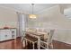 Elegant dining room highlighted by a modern chandelier, a wooden table, and hardwood flooring at 136 Garden Retreat Dr, Garner, NC 27529