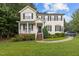 Charming two-story home with a well-manicured lawn and a welcoming front porch and black shutters at 136 Garden Retreat Dr, Garner, NC 27529
