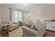 Comfortable living room featuring hardwood floors, cozy seating, and natural light from a large window at 136 Garden Retreat Dr, Garner, NC 27529