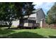 Back exterior of home showcasing screened porch, grassy yard, and mature shade tree at 136 Wedgewood Ct, Sanford, NC 27332