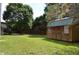 View of backyard featuring wooden storage shed with double doors, mature trees and fenced property line at 136 Wedgewood Ct, Sanford, NC 27332
