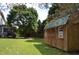 Backyard view featuring wooden storage shed with green roof and double doors near back of house at 136 Wedgewood Ct, Sanford, NC 27332