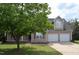 Charming home with a front porch and a two car garage, partially obscured by a tree at 136 Wedgewood Ct, Sanford, NC 27332
