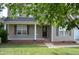 Inviting front porch with brick trim, neutral siding, and a well-manicured lawn at 136 Wedgewood Ct, Sanford, NC 27332