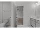 Bright bathroom featuring a modern vanity, and a view through an open doorway to another room, with carpet flooring at 1414 Arena Ln, Fuquay Varina, NC 27526