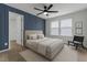 Modern bedroom with a paneled accent wall, ceiling fan, and neutral decor at 1414 Arena Ln, Fuquay Varina, NC 27526