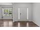 Inviting foyer with hardwood floors, a white front door, and natural light from a window at 1414 Arena Ln, Fuquay Varina, NC 27526