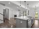 Modern kitchen with gray island, stainless steel appliances, pendant lighting, and hardwood floors throughout at 1414 Arena Ln, Fuquay Varina, NC 27526