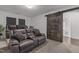 Spacious living room with comfortable seating, theater recliners, and a sliding barn door leading to a bathroom at 1414 Arena Ln, Fuquay Varina, NC 27526